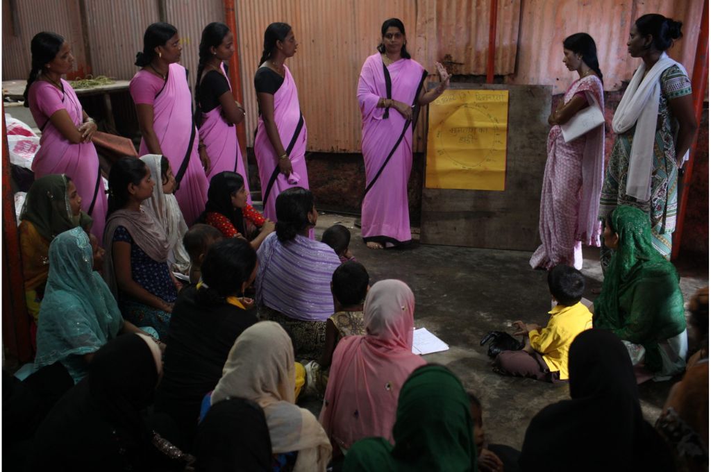 ज़मीन पर बैठी महिलाओं से बात करती महिला सामुदायिक स्वास्थ्य कार्यकर्ता_फ़्रंटलाइन वर्कर