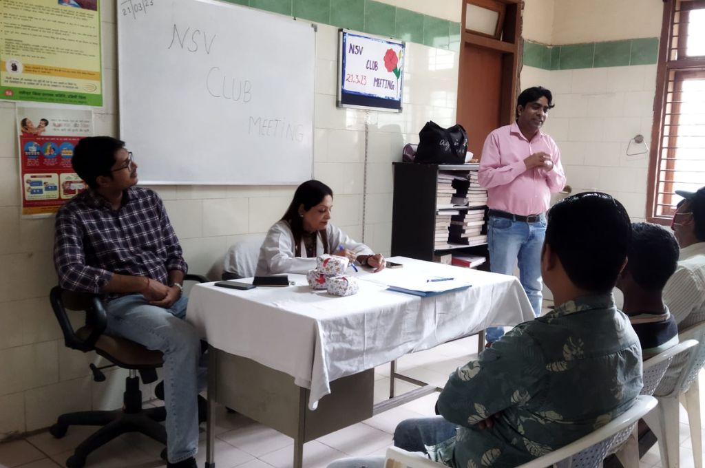 नरेश पुरुषों को नसबंदी के बारे में बताते हुए।