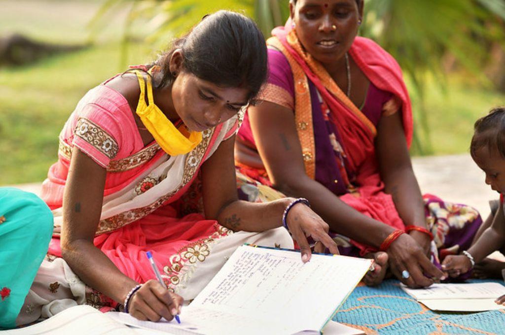 रजिस्टर को भरने का काम करती महिला_सतत विकास लक्ष्य