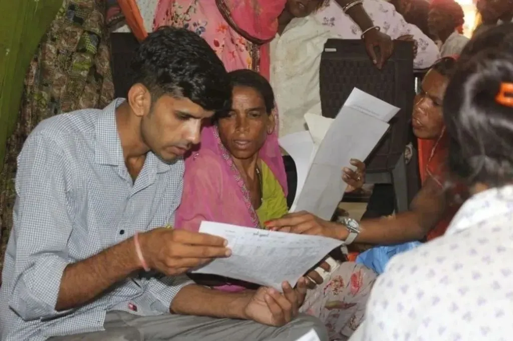 दस्तावेज देखता युवा_प्रधानमंत्री सुरक्षा बीमा योजना