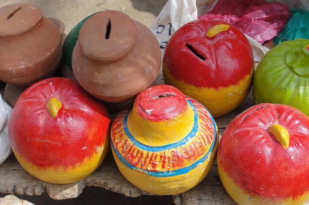 एक मेज़ पर रखे अलग-अलग रंग के गुल्लक_वित्तीय लचीलापन